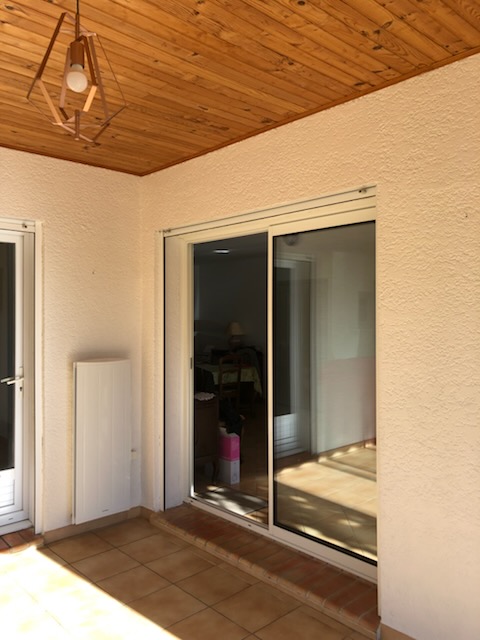 Terrasse couverte rénovée — lambris bois et menuiseries aluminium Hérault