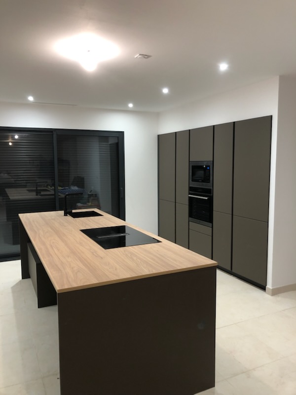 Cuisine moderne avec îlot central bois et noir, spots LED encastrés — Hérault