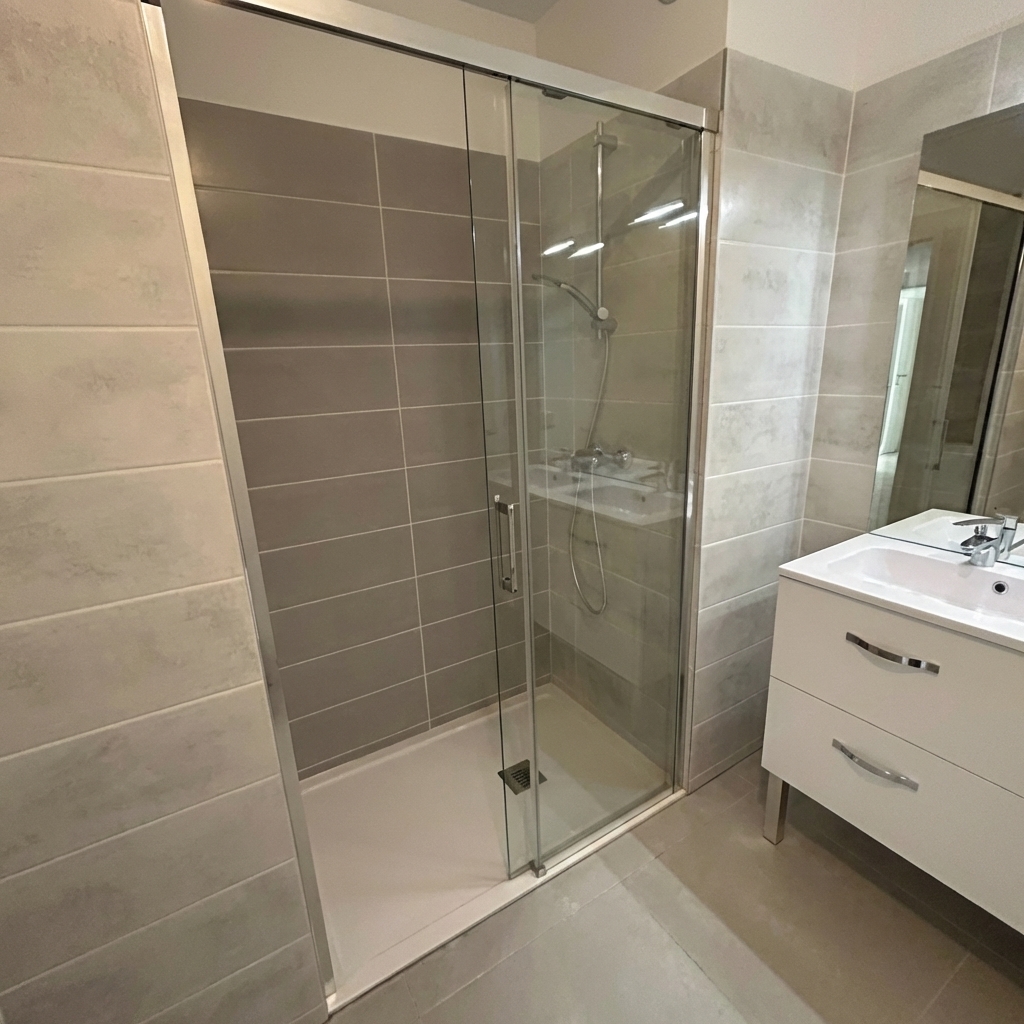 Salle de bain rénovée avec douche à l'italienne et carrelage gris moderne