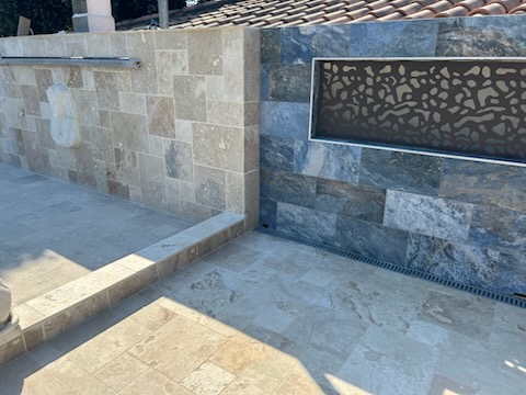 Terrasse en travertin avec margelles de piscine et mur en pierre naturelle — Hérault