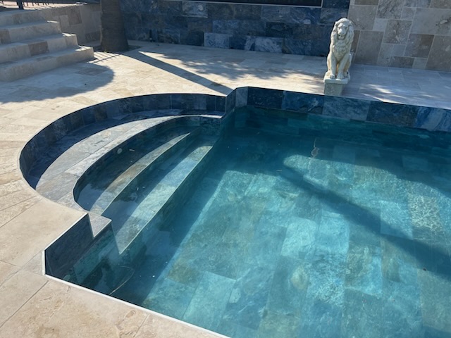 Piscine avec revêtement en travertin clair, escalier intérieur — Hérault