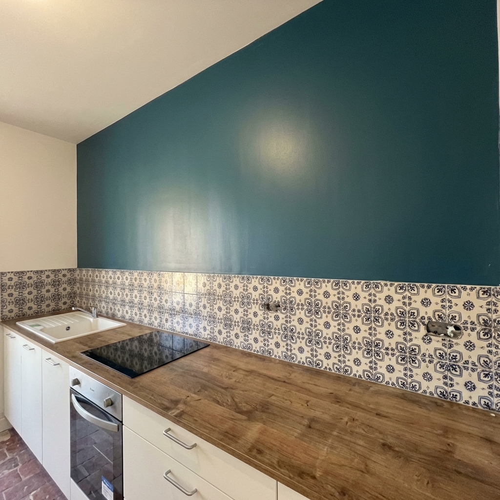 Cuisine avec mur peinture bleu-vert et carrelage mosaïque, plan de travail bois