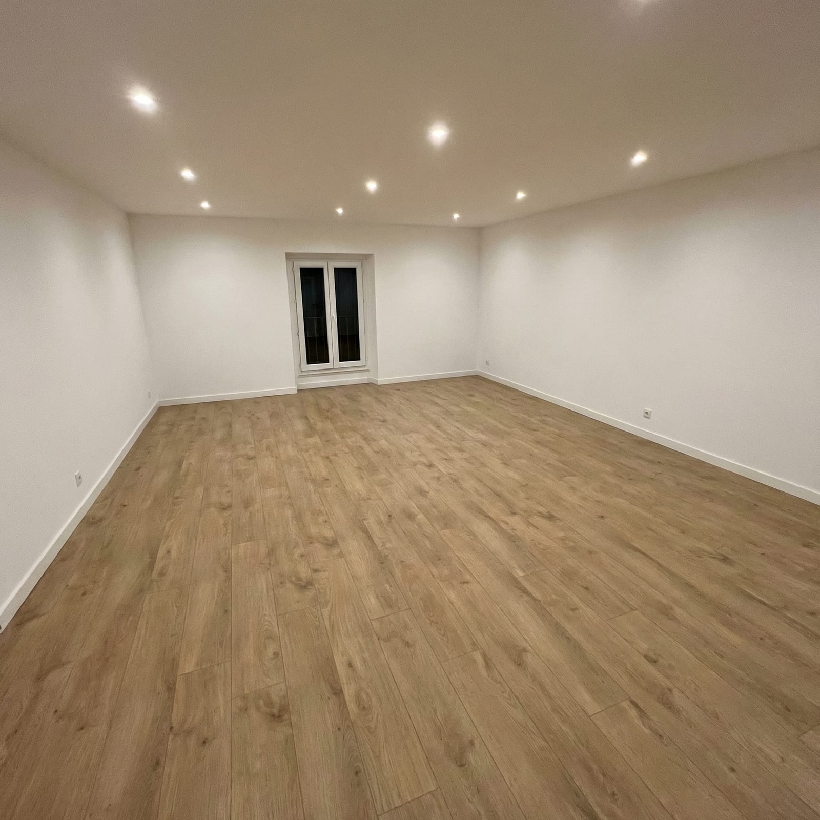 Grande pièce rénovée avec spots encastrés et parquet chêne clair
